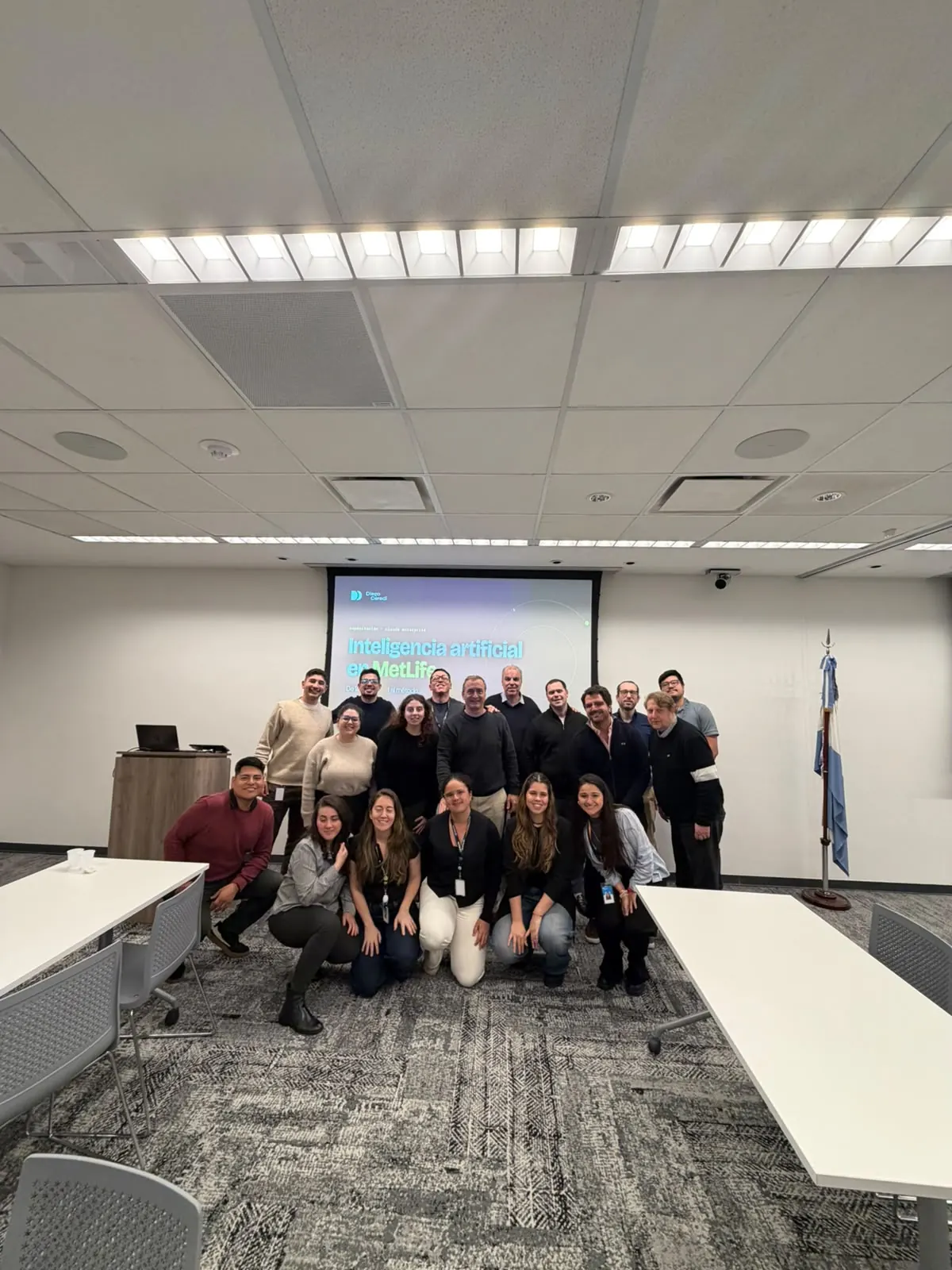 Uno de los grupos de MetLife Argentina al cierre de su workshop de Claude Enterprise, frente a la presentación «Inteligencia artificial en MetLife», octubre de 2026